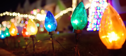 Close-up photo of Christmas and New Year decorations. Fence decorated with a multicolored garland. Outdoor Xmas decorations