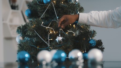 Merry Christmas. Close up of male hands decorating Christmas tree. High quality photo