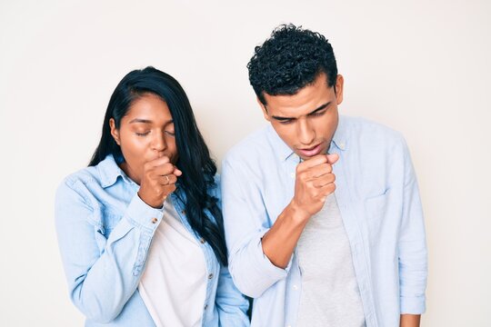 Beautiful latin young couple wearing casual clothes feeling unwell and coughing as symptom for cold or bronchitis. health care concept.