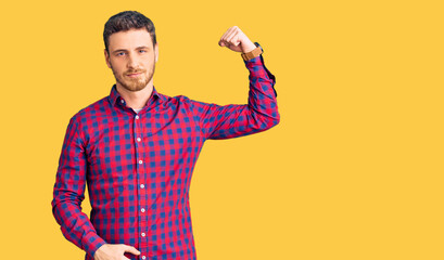 Handsome young man with bear wearing casual shirt strong person showing arm muscle, confident and proud of power