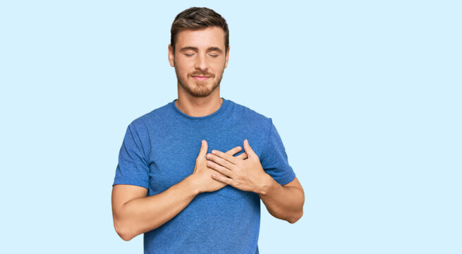 Handsome caucasian man wearing casual clothes smiling with hands on chest with closed eyes and grateful gesture on face. health concept.