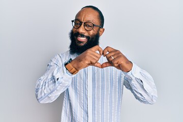Young african american man wearing business style smiling in love doing heart symbol shape with hands. romantic concept.