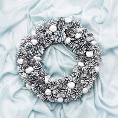 Christmas wreath on blue silk background. Top view, copy space