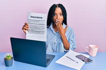 Beautiful hispanic woman at the office showing insurance document covering mouth with hand, shocked...