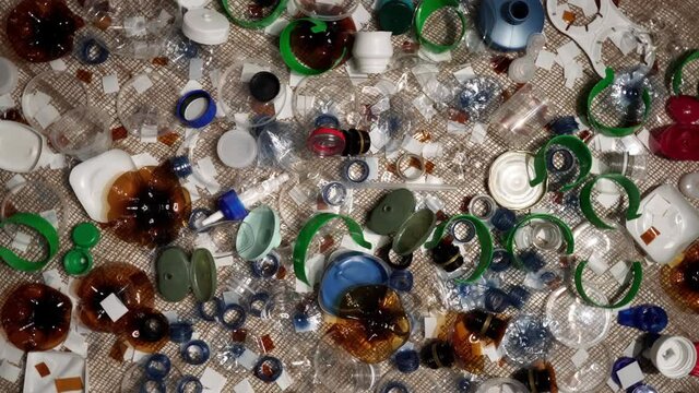 Plastic bottles parts, cups, corks, straws, water and shampoo bottles, creams packaging and other one-time use garbage dumped on the table. Environmental pollution, recycle, waste management problem.