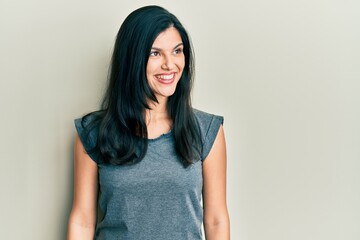 Fototapeta premium Young hispanic woman wearing casual clothes looking to side, relax profile pose with natural face and confident smile.