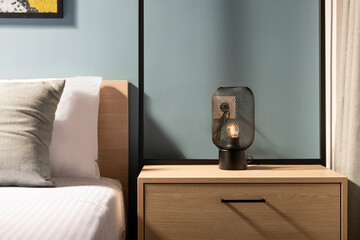 Closeup of modern black metal edison bulb lamp on wooden bedroom night table in contemporary style...