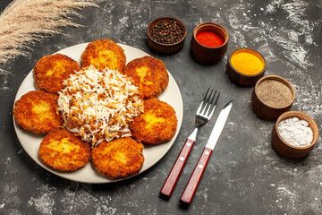 top view fried cutlets with cooked rice and seasonings on dark desk photo food meat dish
