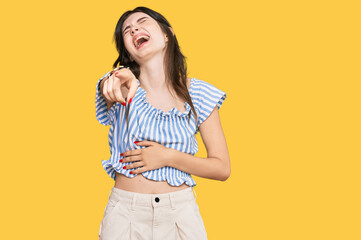 Young beautiful caucasian girl wearing casual clothes laughing at you, pointing finger to the...