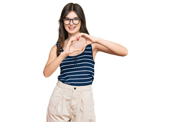 Young beautiful caucasian girl wearing casual clothes and glasses smiling in love doing heart symbol shape with hands. romantic concept.