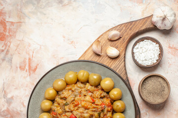 top view roasted eggplant salad on plate on cutting board garlic on nude background free space