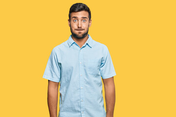 Handsome hispanic man wearing casual clothes puffing cheeks with funny face. mouth inflated with...