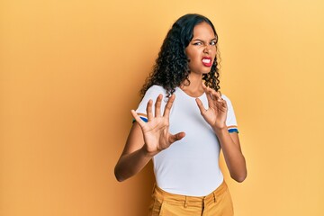 Young african american girl wearing casual clothes disgusted expression, displeased and fearful...