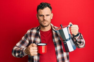Young hispanic man drinking italian coffee skeptic and nervous, frowning upset because of problem. negative person.