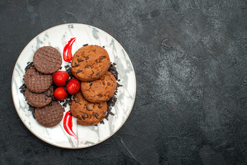 top view delicious choco biscuits for tea inside plate on the dark background sweet cookie cake