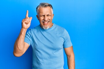 Fototapeta premium Middle age grey-haired man wearing casual clothes pointing finger up with successful idea. exited and happy. number one.