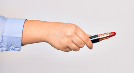 Hand of caucasian young woman holding red lipstick over isolated white background