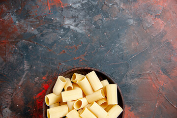 Half shot of uncooked pastas inside the pot on black background stock image