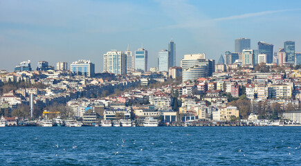 Fototapeta na wymiar Panoramic view of Istanbul European side from the Asian side. Skyscrapers, hotels and modern offices near old historical tradition buildings. Bosporus on the front of image.