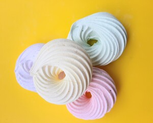Multicolored sugar rings on a yellow background. Sweets, dessert for tea