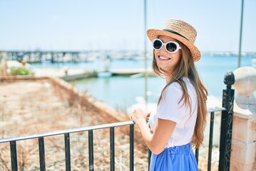 Young blonde woman on vacation smiling happy leaning on balustrade at street of city