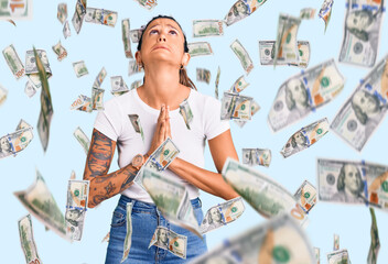 Young hispanic woman with tattoo wearing casual white tshirt begging and praying with hands together with hope expression on face very emotional and worried. begging.