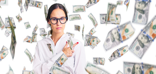 Beautiful brunette young woman wearing professional waitress apron pointing with hand finger to the side showing advertisement, serious and calm face
