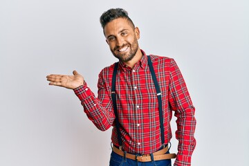 Handsome man with beard wearing hipster elegant look smiling cheerful presenting and pointing with palm of hand looking at the camera.