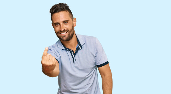 Handsome man with beard wearing casual clothes beckoning come here gesture with hand inviting welcoming happy and smiling