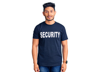 Handsome latin american young man wearing security t shirt with a happy and cool smile on face. lucky person.