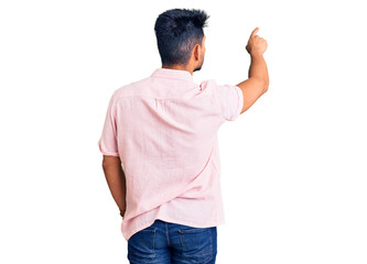 Handsome latin american young man wearing casual summer shirt posing backwards pointing ahead with finger hand