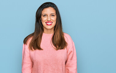 Fototapeta premium Beautiful hispanic woman wearing casual winter sweater looking positive and happy standing and smiling with a confident smile showing teeth