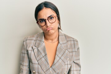 Young brunette woman wearing business jacket and glasses looking sleepy and tired, exhausted for fatigue and hangover, lazy eyes in the morning.