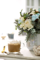 Beautiful winter wedding bouquet and cup of coffee on white marble table indoors