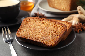 Fresh gingerbread cake slices served on grey table, closeup