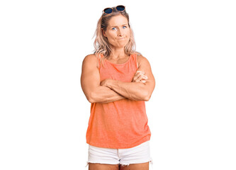 Middle age fit blonde woman wearing casual summer clothes and sunglasses skeptic and nervous,...