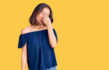 Young beautiful chinese girl wearing casual clothes tired rubbing nose and eyes feeling fatigue and headache. stress and frustration concept.