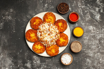 top view fried cutlets with cooked rice and seasonings on dark background food photo meat