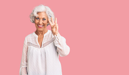 Senior grey-haired woman wearing casual clothes showing and pointing up with fingers number three while smiling confident and happy.