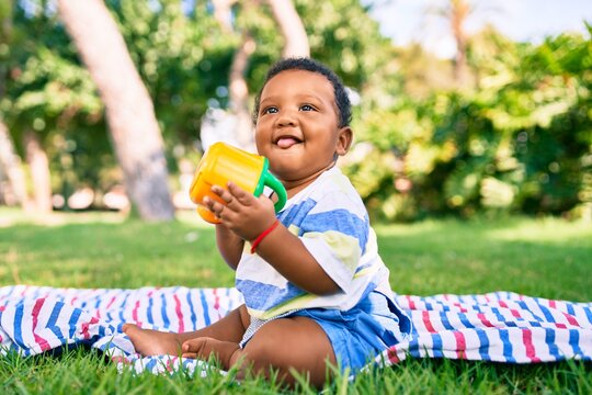 Adorable african american toddler smiling happy playing with toy at the park.