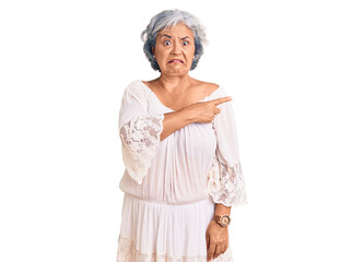 Senior woman with gray hair wearing bohemian style pointing aside worried and nervous with...