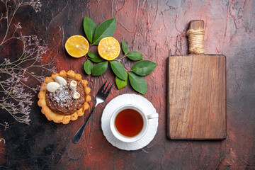 top view cup of tea with delicious little cake on the dark background dessert biscuit cookie