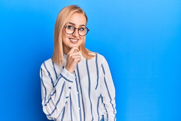 Obraz na płótnie Canvas Beautiful caucasian woman wearing casual clothes and glasses smiling looking confident at the camera with crossed arms and hand on chin. thinking positive.