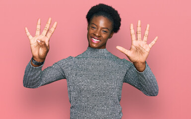 Young african american girl wearing casual clothes showing and pointing up with fingers number nine...