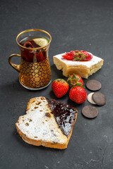 front view yummy cake slices with cup of tea and cookies on dark background sweet biscuit