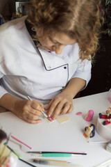 Cake decoration process. Baker uses the tools for sculpting fondant models.Edible art,cake...