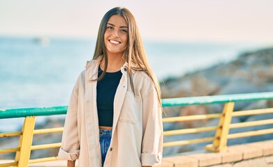 Young hispanic girl smiling happy standing at the promenade.