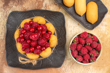 Set table with a gift cake biscuits and fruits on mixed color background