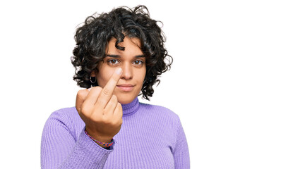Fototapeta na wymiar Young hispanic woman with curly hair wearing casual clothes showing middle finger, impolite and rude fuck off expression