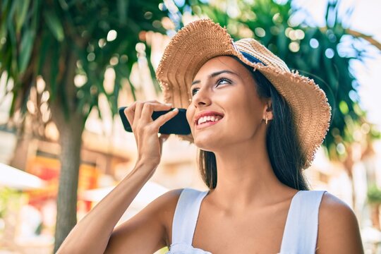 Young latin girl wearing summer style talking on the smartphone at street of city.